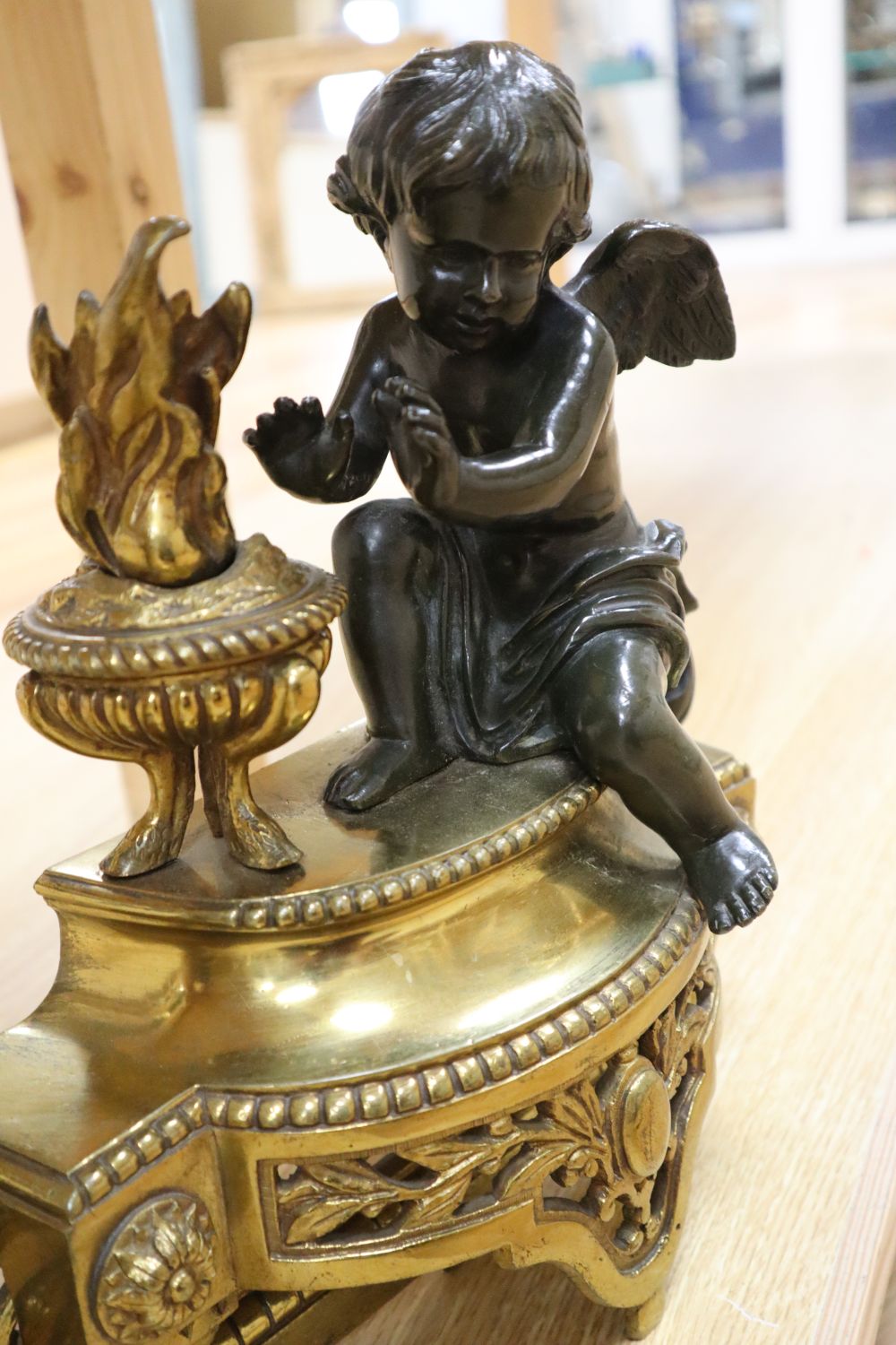 A 19th century French brass fender, classical style with two bronze cherub attendants, width adjustable 129cm max.